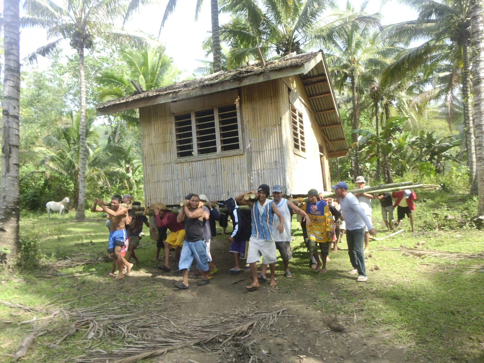 Bayanihan: a bahay kubo lifted on bamboo poles and carried by neighbours. No money changed hands. Source: Bonvallite, kollectivehustle.com.